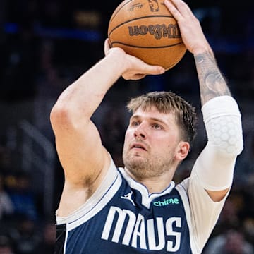 Feb 25, 2024; Indianapolis, Indiana, USA; Dallas Mavericks guard Luka Doncic (77) shoots the ball while Indiana Pacers guard Andrew Nembhard (2) defends in the second half at Gainbridge Fieldhouse. Mandatory Credit: Trevor Ruszkowski-Imagn Images