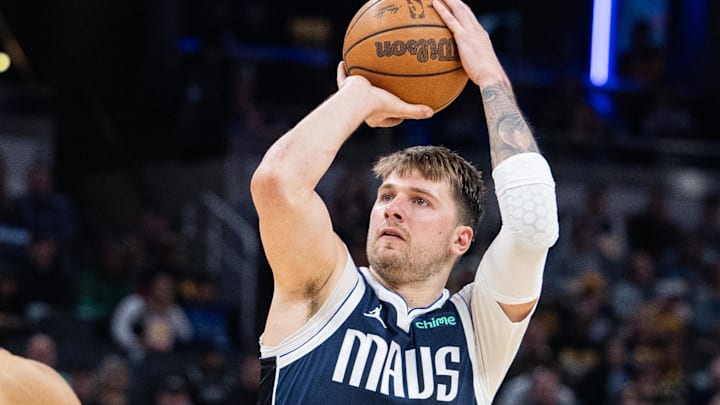 Feb 25, 2024; Indianapolis, Indiana, USA; Dallas Mavericks guard Luka Doncic (77) shoots the ball while Indiana Pacers guard Andrew Nembhard (2) defends in the second half at Gainbridge Fieldhouse. Mandatory Credit: Trevor Ruszkowski-Imagn Images