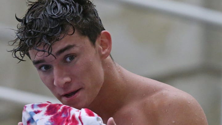 Tyler Downs, competing for USA in the 3-meter synchro, wipes water from his face during a practice ahead of the 2024 Summer Olympics.