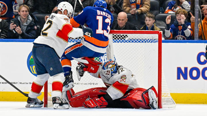 Mar 1, 2026; Elmont, New York, USA; New York Islanders center Mathew Barzal (13) hangs on to the top of the net as Florida Panthers goaltender Sergei Bobrovsky (72) makes a save during the first periodat UBS Arena. Mandatory Credit: Dennis Schneidler-Imagn Images