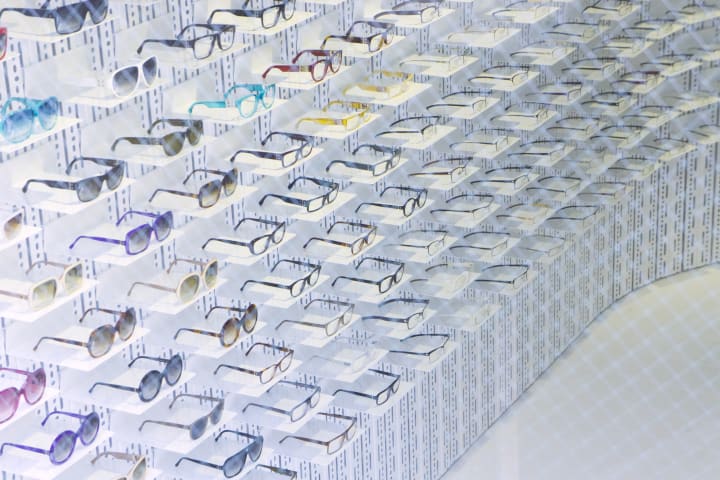 Rows of sunglasses and eyeglasses in a store