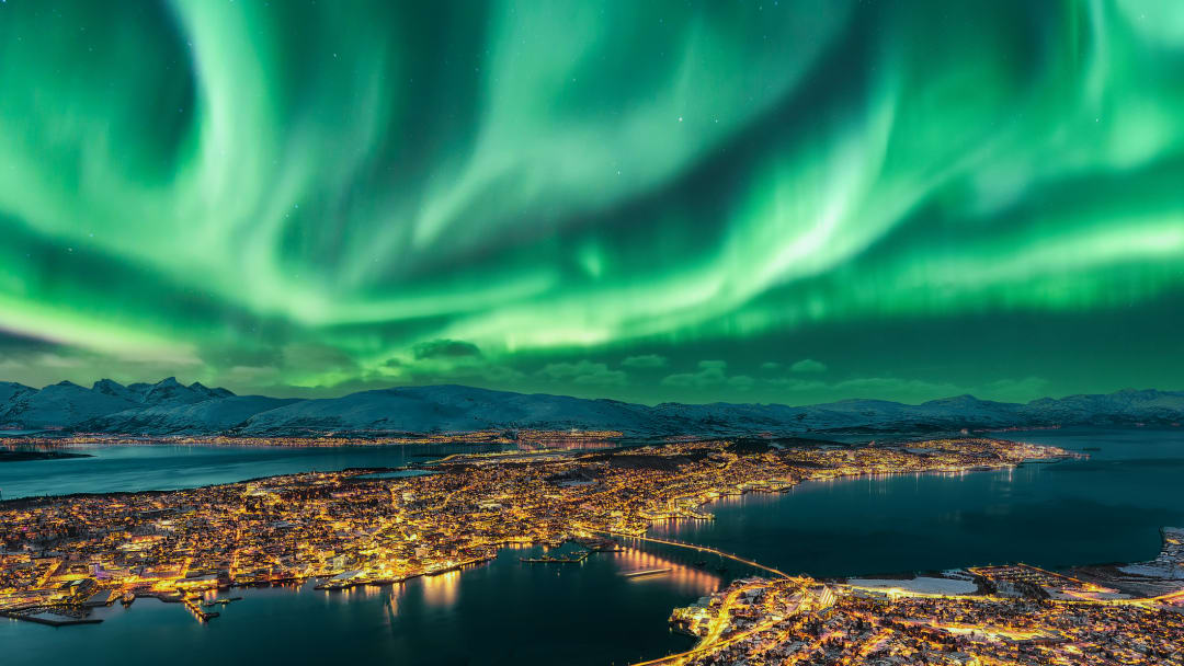 The northern lights—caused by solar or geomagnetic storm—float over Tromsø, Norway.