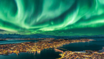 The northern lights—caused by solar or geomagnetic storm—float over Tromsø, Norway.