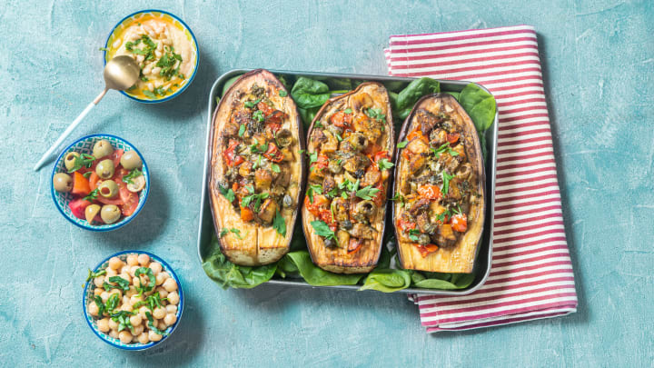 Eggplant stuffed with vegetables in pan.
