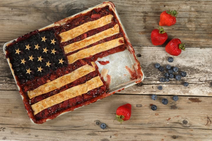 An overhead close up horizontal photograph of a freshly baked Blueberry and strawberry American Flag pie. 