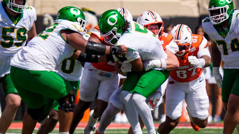 Oregon quarterback Dante Moore is sacked as the Oregon Ducks face the Oklahoma State Cowboys.