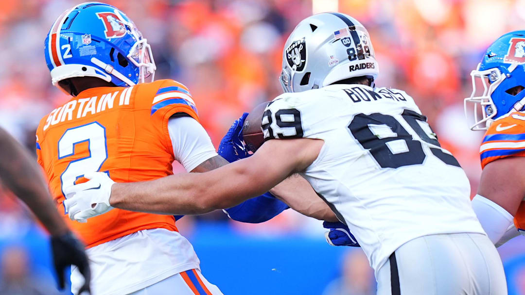 Oct 6, 2024; Denver, Colorado, USA; Denver Broncos cornerback Pat Surtain II (2) brings in a interception away from Las Vegas Raiders tight end Brock Bowers (89) in the fourth quarter at Empower Field at Mile High. Mandatory Credit: Ron Chenoy-Imagn Images