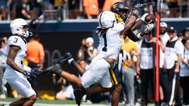 A Penn State player runs toward a West Virginia as he tries to catch a pass.