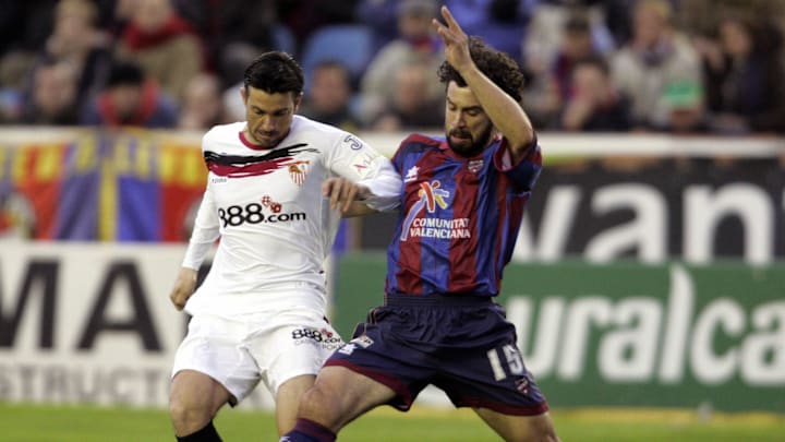 Sevilla's Jose Marti (L) fights for the...