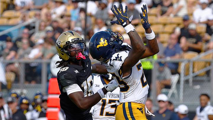 Oct 18, 2025; Orlando, Florida, USA;  West Virginia Mountaineers cornerback Jason Chambers (23) makes an interception on a pass intended for Central Florida Knights wide receiver Waden Charles (19) in the second half at Acrisure Bounce House. Mandatory Credit: Russell Lansford-Imagn Images