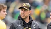 Oregon offensive coordinator Will Stein, left, former Oregon defensive coordinator Nick Aliotti and former Oregon coach Rich Brooks talk before the game as the Fighting Ducks face off against Mighty Oregon in the Oregon Ducks spring game on April 26, 2025, at Autzen Stadium in Eugene.
