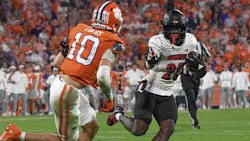 Nov 2, 2024; Clemson, South Carolina, USA; Louisville Cardinals running back Isaac Brown (25) runs the ball against Clemson Tigers cornerback Jeadyn Lukus (10) during the second quarter at Memorial Stadium. Mandatory Credit: Ken Ruinard-Imagn Images