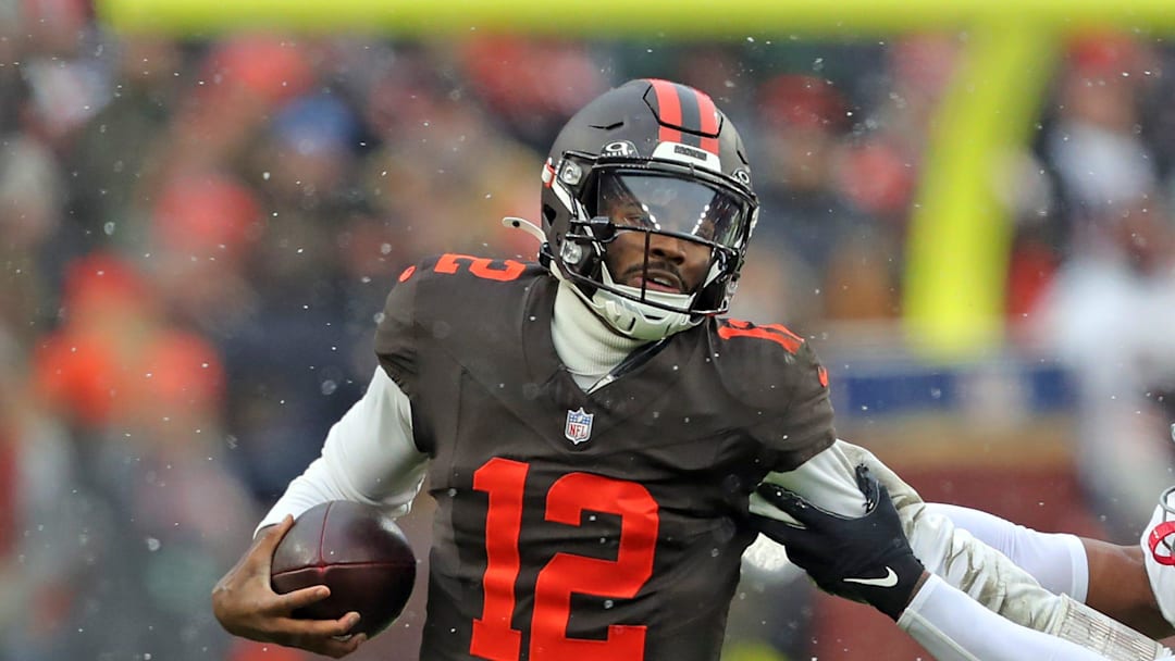Cleveland Browns quarterback Shedeur Sanders (12) picks up a first down on his feet ahead of Tennessee Titans linebacker Cedric Gray (33) during the first half of an NFL football game at Huntington Bank Field, Dec. 7, 2025, in Cleveland, Ohio.