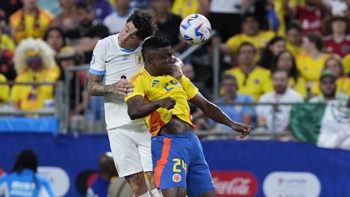 Jul 10, 2024; Charlotte, NC, USA;  Uruguay defender Jose Gimenez (2) and Columbia forward John Cordoba (24) go for a header during the first half at the Copa Armerica Semifinal match at Bank of America Stadium. Mandatory Credit: Jim Dedmon-USA TODAY Sports