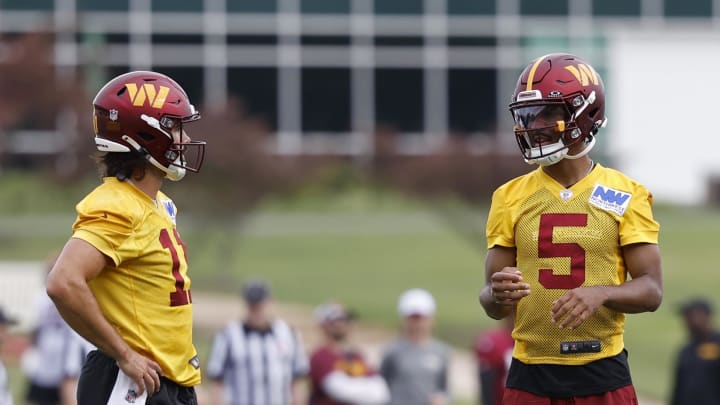 Jul 26, 2024; Ashburn, VA, USA; Washington Commanders quarterback Jayden Daniels (5) talks with Commanders quarterback Sam Hartman (11) on day three of training camp at Commanders Park. Mandatory Credit: Geoff Burke-USA TODAY Sports