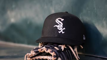 A detailed view of a Chicago White Sox hat and glove in the dugout against the Atlanta Braves in the fourth inning at Truist Park in 2023.