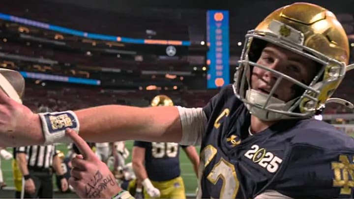 Notre Dame quarterback Riley Leonard points to a bible verse on his arm band after a touchdown at the national championship vs. Ohio State.