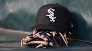 Jul 14, 2023; Atlanta, Georgia, USA; A detailed view of a Chicago White Sox hat and glove in the dugout against the Atlanta Braves in the fourth inning at Truist Park. Mandatory Credit: Brett Davis-Imagn Images