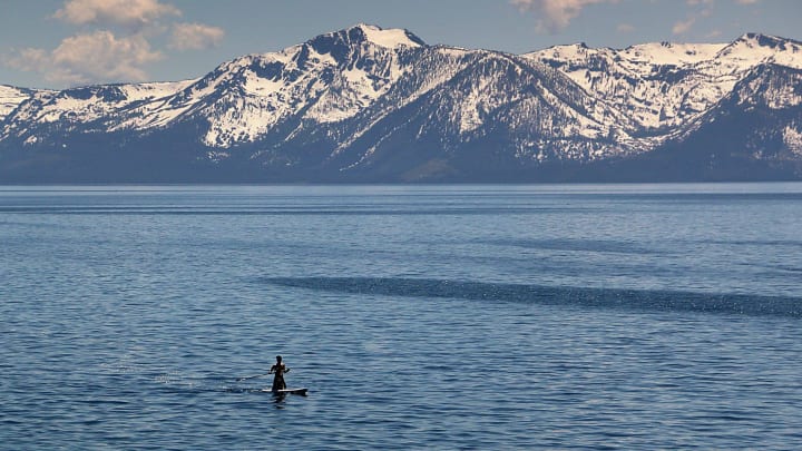 A person on a paddle board heads north along the east shore of Lake Tahoe on May 15, 2024.