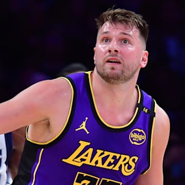 Feb 25, 2025; Los Angeles, California, USA; Los Angeles Lakers guard Luka Doncic (77) and Dallas Mavericks guard Kyrie Irving (11) attempt to gain control during the first quarter at Crypto.com Arena. Mandatory Credit: Gary A. Vasquez-Imagn Images