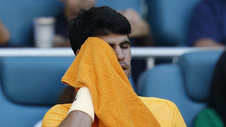 Carlos Alcaraz wipes his face