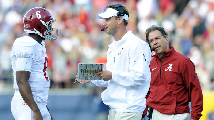 Alabama Crimson offensive coordinator Lane Kiffin talks with quarterback Blake Sims as head coach Nick Saban looks on.