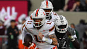 Nov 22, 2025; Blacksburg, Virginia, USA; Miami (FL) Hurricanes quarterback Carson Beck (11) runs the ball as Virginia Tech Hokies defensive lineman Elhadj Fall (94) defends at Lane Stadium. Mandatory Credit: Brian Bishop-Imagn Images