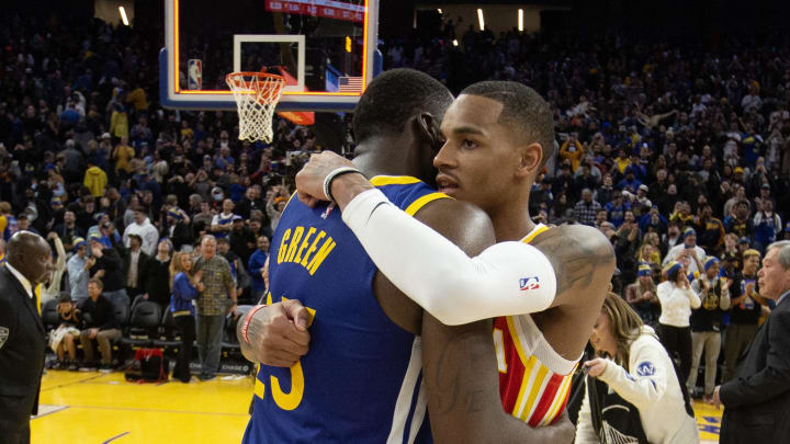 Jan 2, 2023; San Francisco, California, USA; Golden State Warriors forward Draymond Green (23) embraces Atlanta Hawks guard Dejounte Murray (5) following their game at Chase Center. The Warriors defeated the Hawks in double overtime 143-141. Mandatory Credit: D. Ross Cameron-USA TODAY Sports