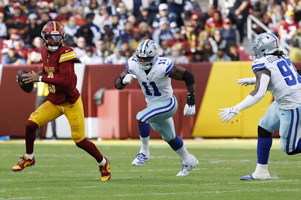 Washington Commanders quarterback Jayden Daniels scrambles from Dallas Cowboys linebacker Micah Parsons