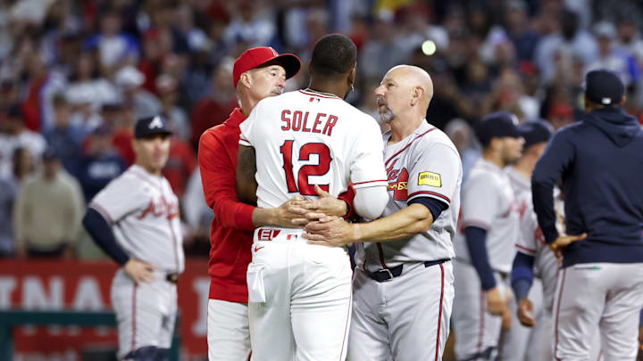 Apr 7, 2026; Anaheim, California, USA; Los Angeles Angels right fielder Jorge Soler (12) speaks with coaching staff after a fight breaks out with Atlanta Braves pitcher Reynaldo López (40) during the fifth inning at Angel Stadium. Mandatory Credit: William Navarro-Imagn Images
