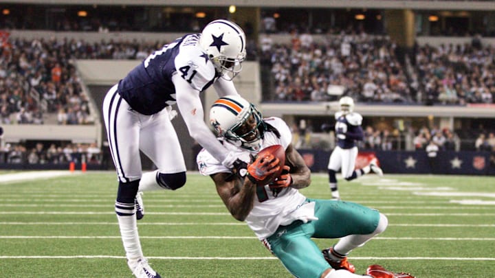 Miami Dolphins wide receiver Brandon Marshall (19) catches a touchdown pass against Dallas Cowboys cornerback Terence Newman (41) in the third quarter on Thanksgiving day at Cowboys Stadium in 2011. Miami Dolphins wide receiver Brandon Marshall (19) catches a touchdown pass against Dallas Cowboys cornerback Terence Newman (41) in the third quarter on Thanksgiving day at Cowboys Stadium in 2011.