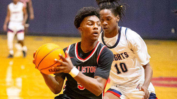 Williston High School guard Deandre Harvey (5) gets pressure from Vanguard's Jandrian Smith (10) as Vanguard takes on Williston during the Kingdom of the Sun basketball tournament at Vanguard High School in Ocala on Thursday, Dec. 28, 2023. Williston won 42-30.