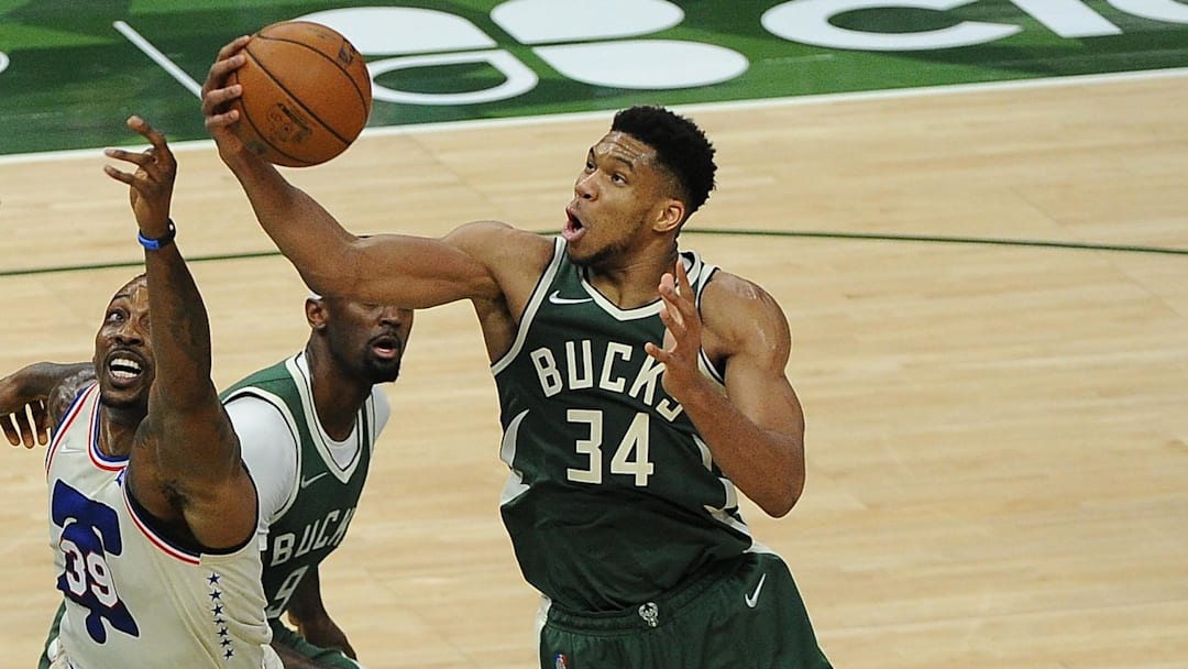 Apr 24, 2021; Milwaukee, Wisconsin, USA;  Milwaukee Bucks forward Giannis Antetokounmpo (34) grabs a rebound in front of Philadelphia 76ers center Dwight Howard (39) in the second quarter at Fiserv Forum. Mandatory Credit: Michael McLoone-Imagn Images