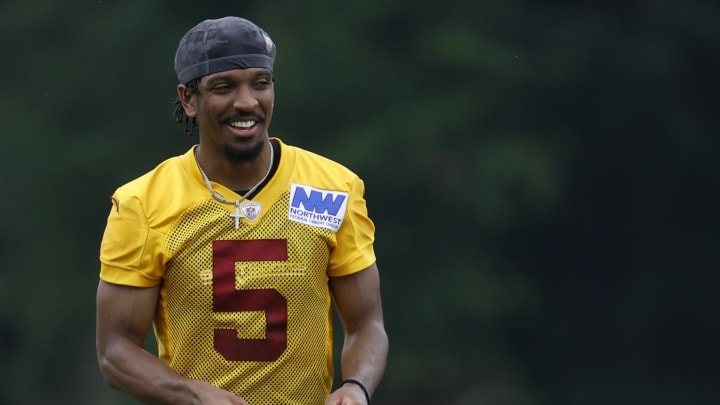 Jun 5, 2024; Ashburn, VA, USA; Washington Commanders quarterback Jayden Daniels (5) smiles on the field during an OTA workout at Commanders Park. Mandatory Credit: Geoff Burke-USA TODAY Sports