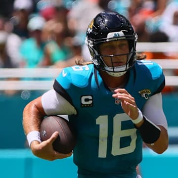 Sep 8, 2024; Miami Gardens, Florida, USA; Jacksonville Jaguars quarterback Trevor Lawrence (16) runs with the football against the Miami Dolphins during the first quarter at Hard Rock Stadium. Mandatory Credit: Sam Navarro-Imagn Images