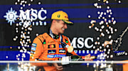 Lando Norris celebra con champaña en el podio tras ganar el Gran Premio de Brasil de Fórmula 1 en el Autódromo José Carlos Pace