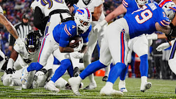 Buffalo Bills running back James Cook, carrying the ball, keeps low as teammate Buffalo Bills offensive tackle Spencer Brown blocks opening a spot for him during first half action at the Buffalo Bills divisional game against the Baltimore Ravens at Highmark Stadium in Orchard Park on Jan. 19, 2025.