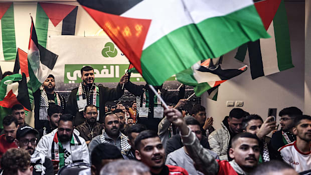 Aficionados palestinos reaccionan mientras se reúnen en un café de la ciudad de Ramala, en Cisjordania ocupada por Israel