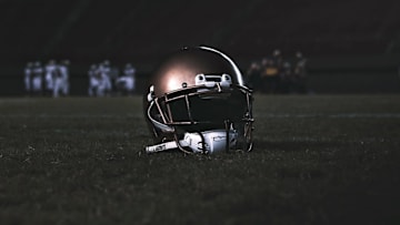 a high school football helmet sits on a field