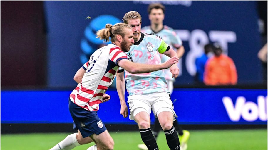 Kevin De Bruyne plays a pass for Belgium as Tim Ream closes down.