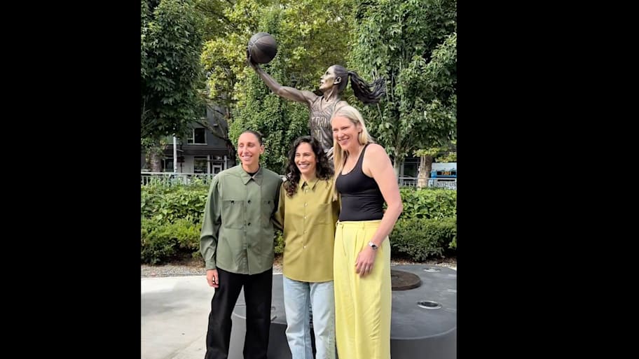 Sue Bird and Diana Taurasi pose in front of Bird's statue outside the Climate Pledge Arena.  | WNBA