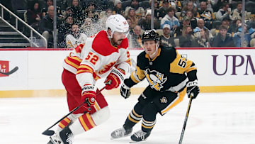 Nov 30, 2024; Pittsburgh, Pennsylvania, USA;  Calgary Flames defenseman MacKenzie Weegar (52) moves the puck against Pittsburgh Penguins center Philip Tomasino (53) during the first period at PPG Paints Arena. Mandatory Credit: Charles LeClaire-Imagn Images