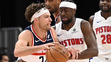 Oct 16, 2025; Detroit, Michigan, USA; Washington Wizards forward Corey Kispert (24) tries to drive past Detroit Pistons guard Caris LeVert (8) in the first quarter at Little Caesars Arena.