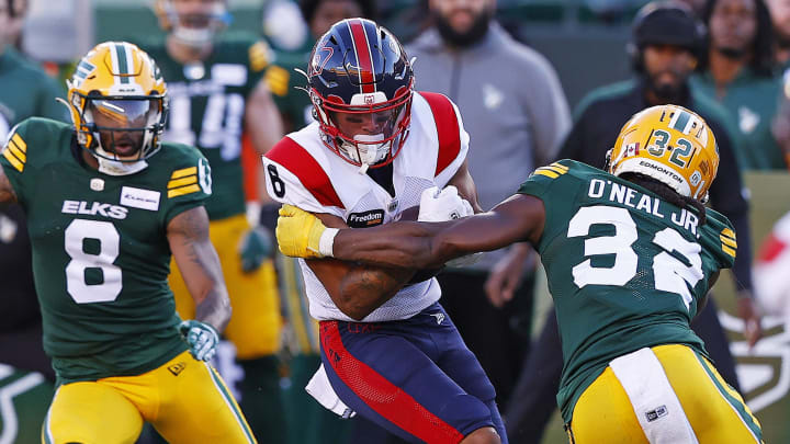 Jun 14, 2024; Edmonton, Alberta, CAN; Edmonton Elks defensive back Leon O'Neal Jr. (32) tries to tackle Montreal Alouettes defensive back Nafees Lyon (8) during the second half at Commonwealth Stadium. Mandatory Credit: Perry Nelson-USA TODAY Sports