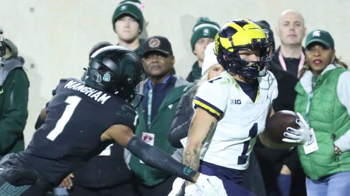 ]Michigan Wolverines wide receiver Roman Wilson (1) runs by Michigan State Spartans defensive back Jaden Mangham (1) for a touchdown during first-half action at Spartan Stadium in East Lansing on Saturday, Oct. 21, 2023.