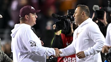 Nov 30, 2024; College Station, Texas, USA; Texas A&M Aggies head coach Mike Elko, left, shakes hands with Texas Longhorns head coach Steve Sarkisian after the game. The Longhorns defeated the Aggies 17-7. at Kyle Field. Mandatory Credit: Maria Lysaker-Imagn Images 