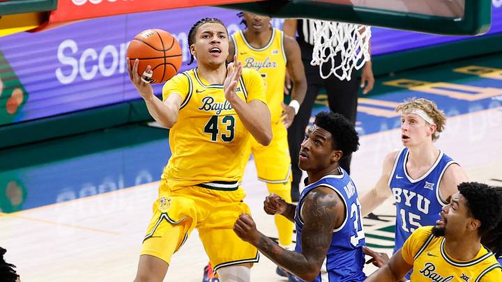 Feb 10, 2026; Waco, Texas, USA; Baylor Bears guard Cameron Carr (43) drives to the basket for a layup past BYU Cougars guard Robert Wright III (1) during the second half at Paul and Alejandra Foster Pavilion. Mandatory Credit: Chris Jones-Imagn Images