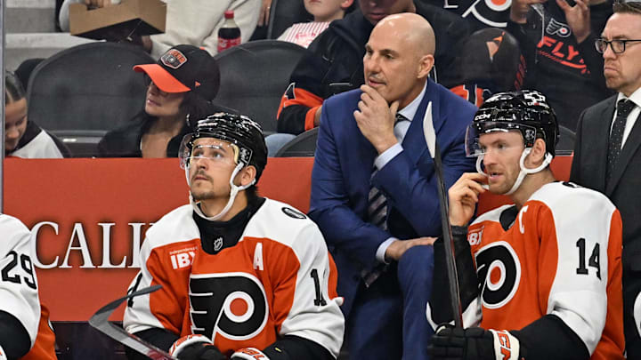 Oct 13, 2025; Philadelphia, Pennsylvania, USA; Philadelphia Flyers head coach Rick Tocchet with right wing Travis Konecny (11) and center Sean Couturier (14) against the Florida Panthers during the first period at Wells Fargo Center. Mandatory Credit: Eric Hartline-Imagn Images