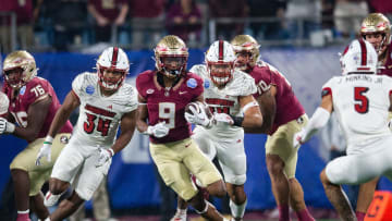 Florida State running back Lawrance Toafili (9) dodges Louisville defenders during the ACC