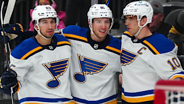 Jan 20, 2025; Las Vegas, Nevada, USA; St. Louis Blues center Brayden Schenn (10) celebrates with center Dylan Holloway (81) and center Jordan Kyrou (25) after scoring a goal against the Vegas Golden Knights during the first period at T-Mobile Arena. Mandatory Credit: Stephen R. Sylvanie-Imagn Images